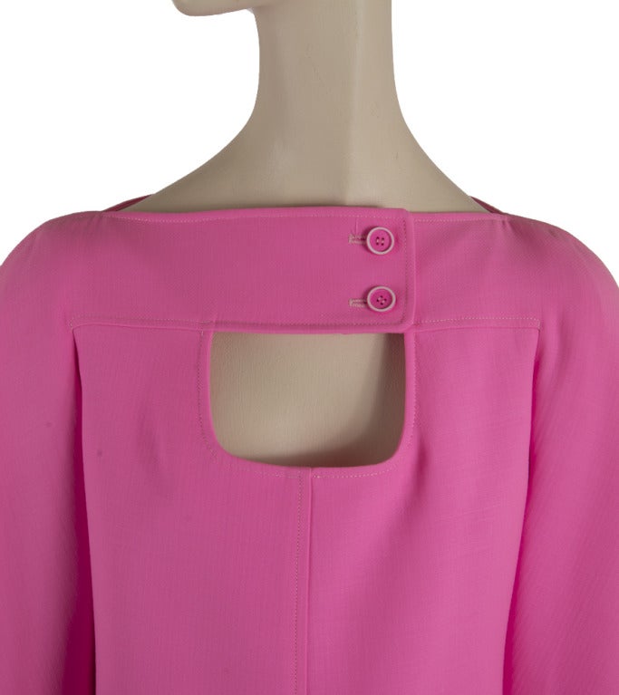This dress is Courreges.  It is bright pink in color with a peek-a-boo chest and back.  It has a zipper and button closure in the back.  It also has button detail on the front.  Fabric content is not marked.   Great for the Courreges lover!