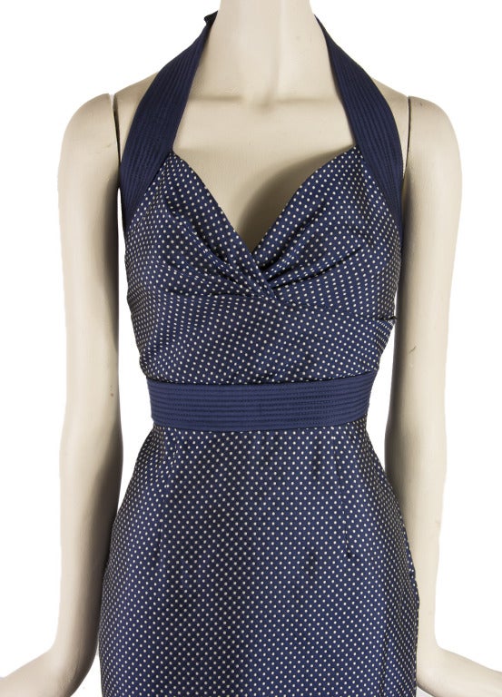 This Alexander McQueen is presented in navy with white polka dot silk.  It is halter style with snaps around the halter.  It has a side zip up and a band waist.  This dress was created before the untimely death of Alexander McQueen and is rare! The