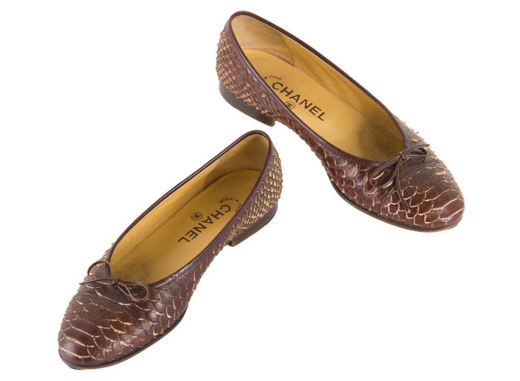 Features classic ballet flat shape made from gorgeous brown python.  Cap toe, interlocking C's and bow at toe.  Made in Italy.  The total length of the shoes measures 9.5 inches. They are a size 37. This pair of shoes in this color and material