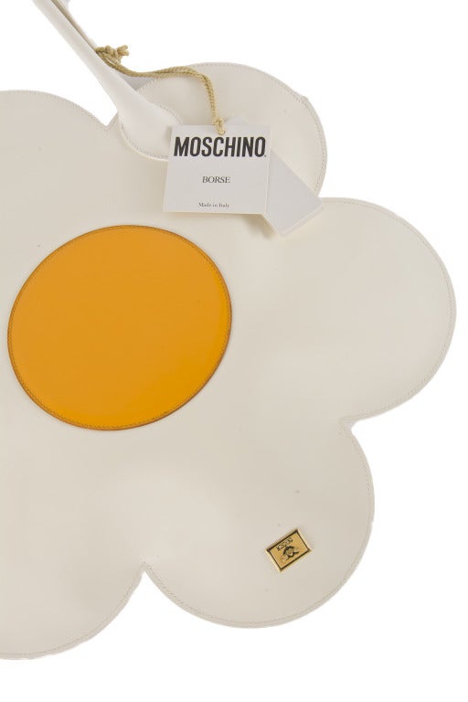 This new daisy purse by Moschino is very rare and hard to find.  It is white leather with a yellow center and gold tone Moschino logo.  It has leather handles and comes with the dust bag.  Large and roomy interior, can hold a lot of stuff!  Bag has