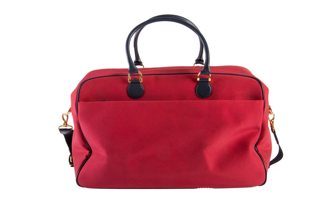 Stunning new Roberta DiCamerino large carry on/duffel/overnight bag in thick red fabric with green suede and black leather.  It also has a long clip on strap, gold tone hardware and id tag and two compartments.