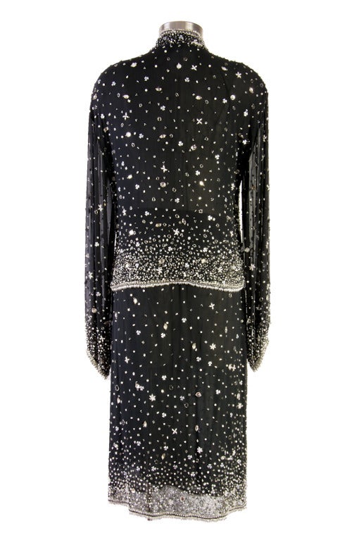 This Halston two piece skirt set is presented in black chiffon/silk with  lots of beadwork. Property of Liza Minelli. The evening jacket is long sleeve with no closure. The skirt features an elastic waist.  Perfect for a fancy evening event.

Jacket