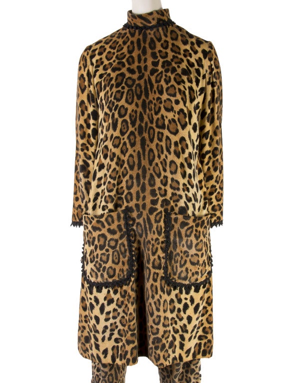 This pantsuit by Mollie Parnus is presented in a leopard print of soft velvet.  The long sleeve top has a stand up collar, two front pockets and a zip up the back with an eye hook closure.   The pants also feature a zipper and eye hook closure. 