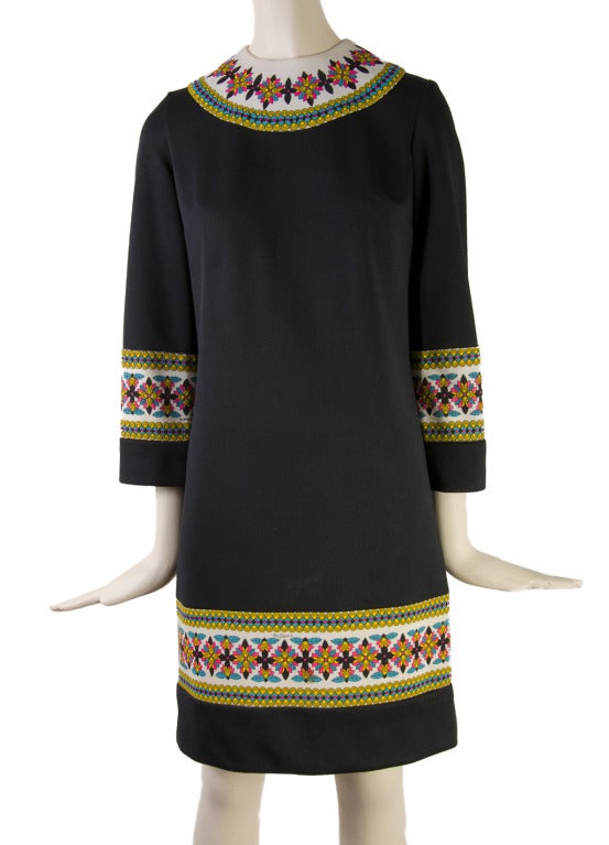 Presented here is a gorgeous vintage dress from Mr. Dino. Mr. Dino designed for the Emilio Pucci label before branching out on his own with his own label. This 1960's dress features a colorful floral border around the neckline, sleeves and bottom. 