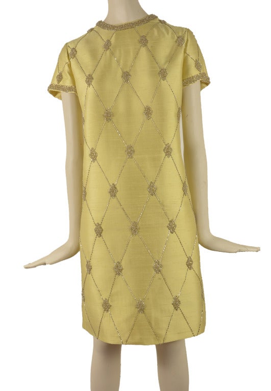 This 1960's vintage two piece set is presented in chartreuse shantung.  Both pieces are adorned with beading.  The dress is short sleeve with an argyle beaded pattern and it has a stiff muslin lining.  The matching jacket also features matching