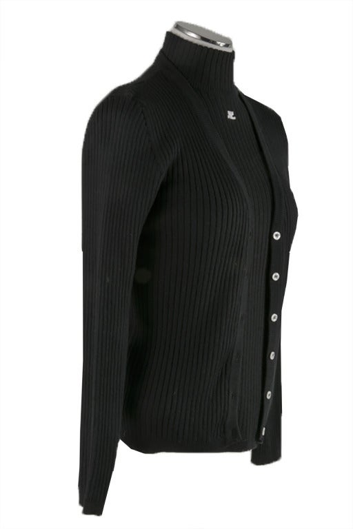 This new black ribbed knit cardigan by Courreges is a wool/acrylic blend that features a front button closure, long sleeves and banded sleeves and waist.  It also sports a Courreges logo on the left breast .  The under sweater is a black ribbed knit