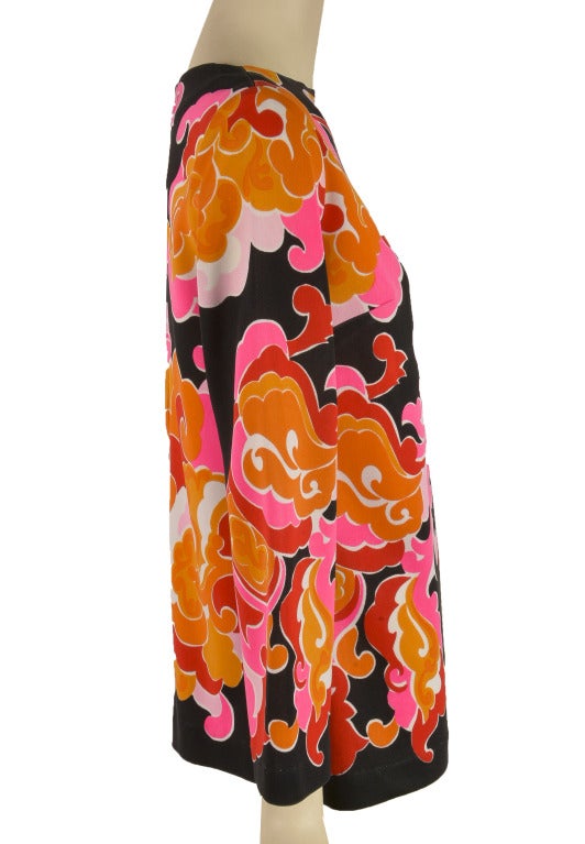 This vintage 1960's Mr. Dino top is presented in bright orange, pink, black and white.  It has long sleeves and a zip and eye hook closure in back.  Inspires the flower power of the 1960's.