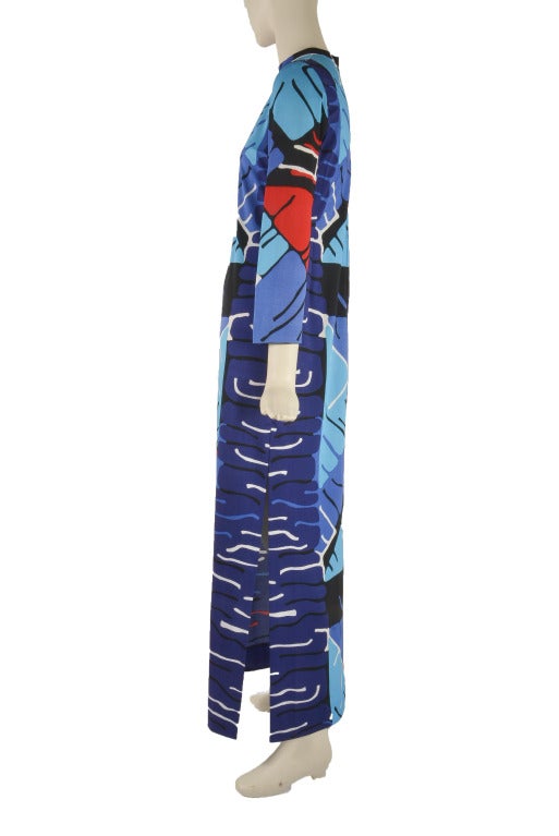 This vintage 1960's maxi dress by Elinor Simmons for Malcolm Star is presented in mod print that features red, turquoise, blue, black and white.  It has long sleeves, stand up collar and a zipper and eye hook closure.  There are a few small stags