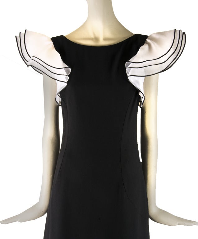Vintage Estevez dress is presented in black with white taffeta puffy sleeves.  It has a zip up the back with an eye hook closure.  It is fully lined.