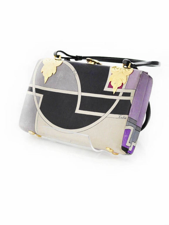 Vintage Emilio Pucci hardcase handbag in fuchsia, purple, light purple, grey, black and cream signed twill print. Handbag has beautiful gold leaf hardware and clasp, black leather straps and lining. 

Measurements:

Height: 5