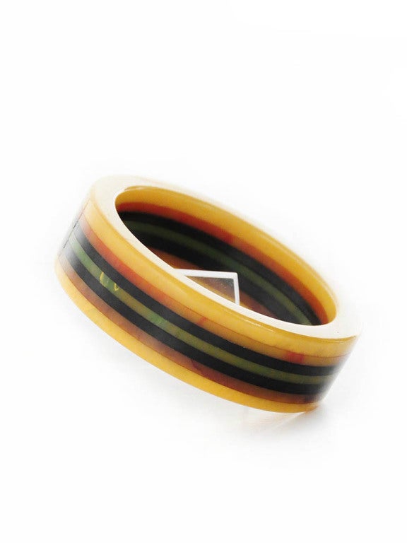 Presented here is a very unique lucite bangle. This beautiful vintage multi layered bracelet is composed of 7 different layered rings. The rings are colors of green, orange, brown, black and green. The bangle is in excellent condition. A beautiful