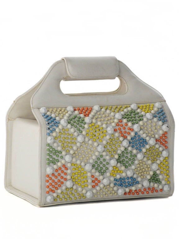 Vintage Judith Leiber white leather handbag with coral, green, teal, yellow, cream and white metal stud embellishment on back and front. Handle has leather wrap strap with snap closure. Side flaps also have snap closure when folded in. Mustard