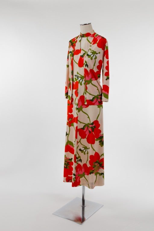 Super groovy, boldly patterned sleeveless dress with banded neckline and keyhole. Dramatic flower pattern in tangerine orange, pink, green and white on a creamy background; seam from bottom of center keyhole opening to hem; side darts and back