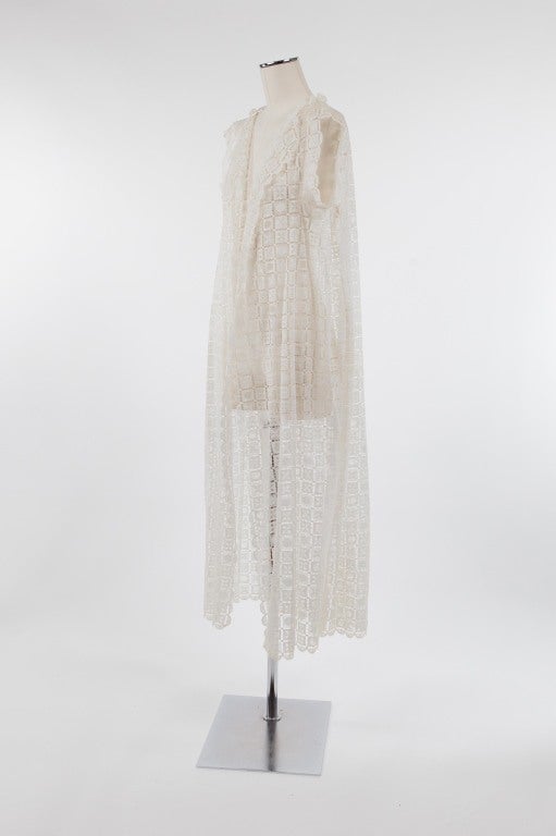 Long, white open robe with geometric lace pattern of alternating flower and circle design. Cap-like sleeves with backside inverted pleat. Light and airy - perfect for the beach, a pool party or lounging around the house.

Photography provided by