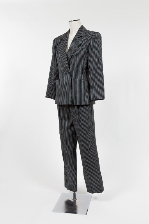 Yves Saint Laurent Rive Gauche three piece suit includes a gabardine black twill with white and gray pinstriped jacket, skirt and trousers. Fully lined single breasted jacket with four front pockets and fastened with a single button; firm shoulder