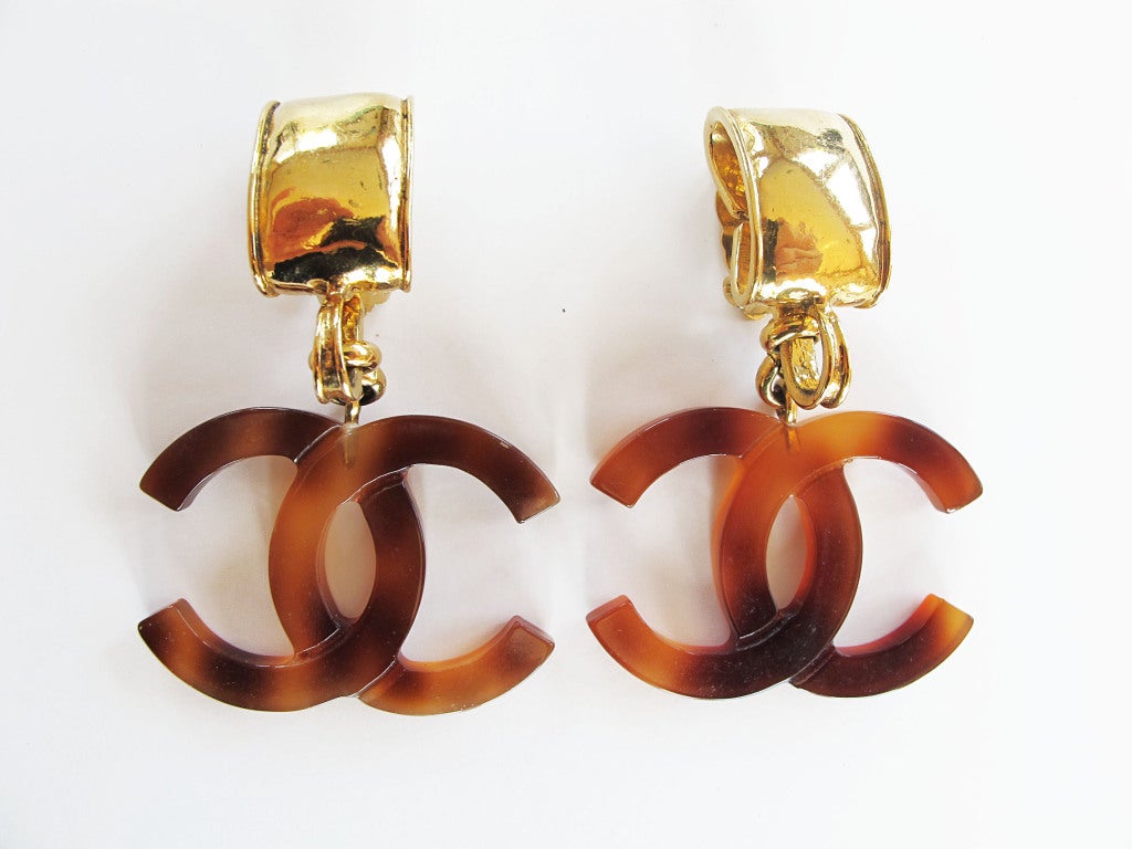 Spring 1994 clip-on Chanel earrings with dangling interlocked CC logo in a tortoise shell print lucite. These fabulous earrings are 3 inches long and 1 7/8 inches wide.

Photography provided by Roberto Rosas-Mariscal for Helpers House of Couture.
