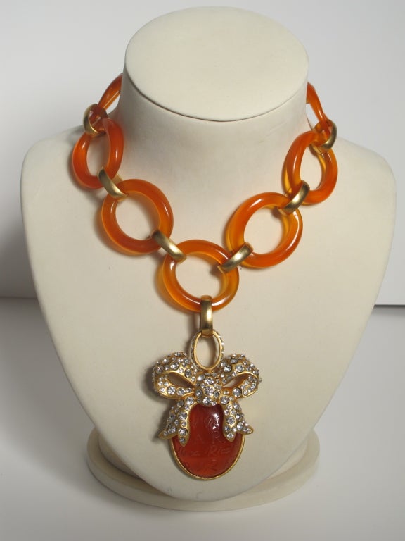1980's Nina Ricci amber hued lucite chain link necklace with jewel encrusted pendant. Signed: Nina Ricci Paris. Pendant measures 3 inches long and is 2.25 inches wide. Necklace measures 17 inches long.

Photography provided by Roberto