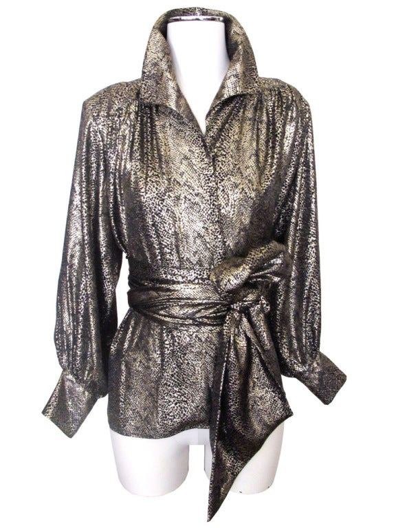 Make a statement in this Rive Gauche black and gold silk metallic reptilian-inspired print blouse. Shirt secures with hidden snaps down center and artfully kept closed with a Japanese obi-style sash which wraps around twice. Light gathering below