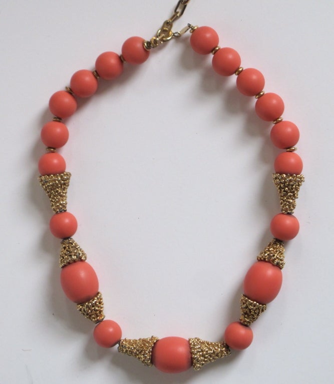 Gorgeous Christian Dior necklace from 1973 with gold tone metal and salmon colored beads. Spring ring clasp closure can adjust the necklace from 14.5-16.5 inches.

Photography provided by Roberto Rosas-Mariscal for Helpers House of Couture.