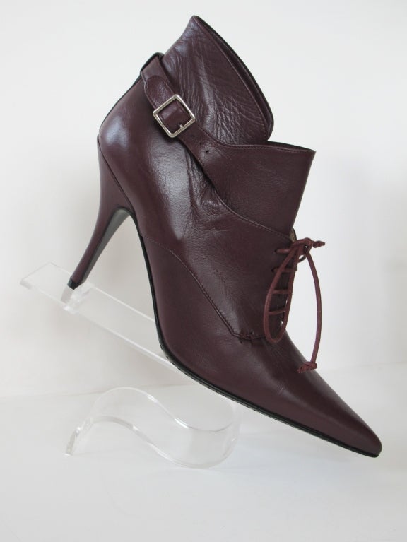 Burgundy lace up high heel booties with ankle strap and accentuated pointed toe. Sole of shoe is sewn with whip stitch.

Photography provided by Roberto Rosas-Mariscal for Helpers House of Couture.