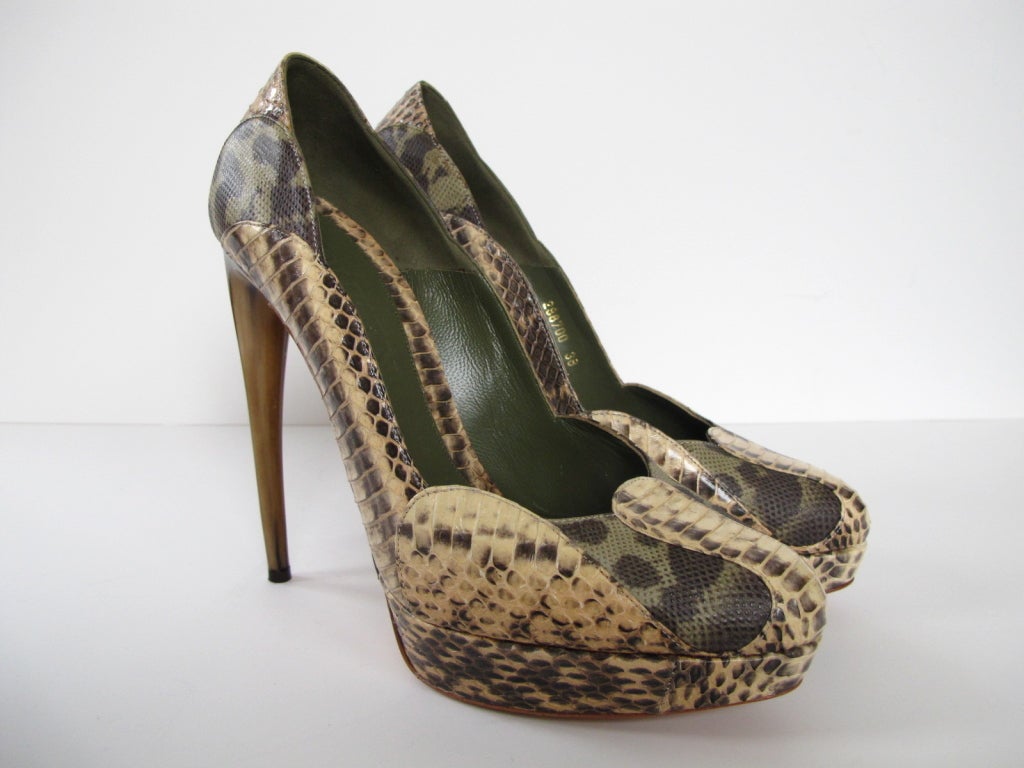 These platform pumps from Spring 2012 Collection feature python paneled with olive green water snake, a low-dipped vamp, innovative curved horn heel, leather innersole and scalloped sides. Shoes feature a 5.25