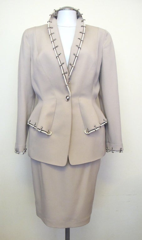 Light beige suit with nautical cream cording and silver closures on cuffs and collar. Striking when worn. New with original tags stating $3,195.00. Marked size 42, reads modern size 8. Skirt is 23