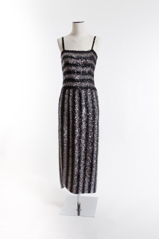 Shimmery ankle length silver and black sequin dress with sequin trimmed spaghetti straps; bodice with horizontal oriented sequins, vertically oriented sequins from waistline to hem; 21" side slit with rounding off hemline. Dazzle them as you