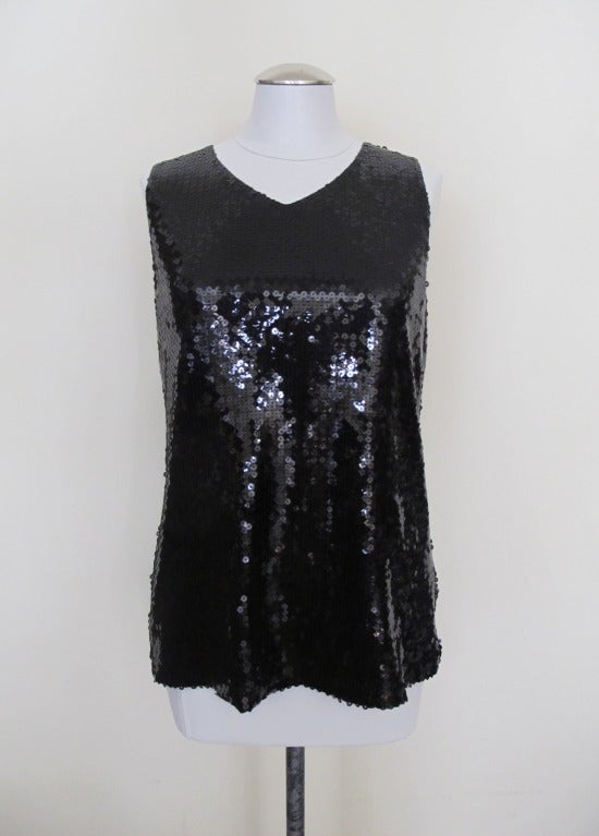 Black Sequin sleeveless Chanel blouse with high v-neckline and key hole buttoned back. Slight stretch. Includes extra sequins. Shoulder to shoulder 13 inches.