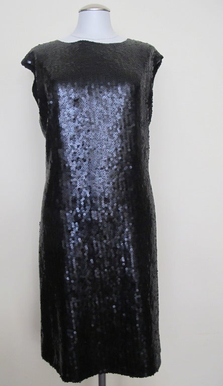 Black Sequin Cocktail Dress with straight silhouette and a sheer Chanel lining with flower motif and a slight cap sleeve. Shoulder to shoulder 19 inches.