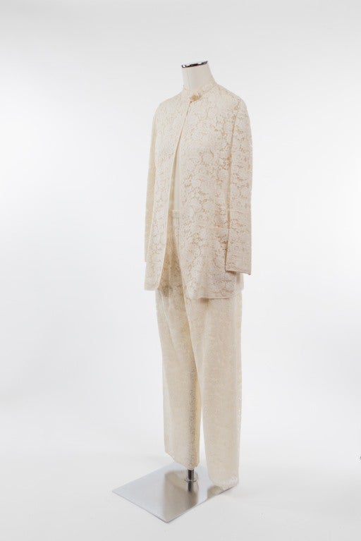 Stunning lace pantsuit with Nehru-style collared two-pocket open jacket over matching silk lined pants. Jacket secures with two snaps at collar under a horn button faux closure. Pants measure 27
