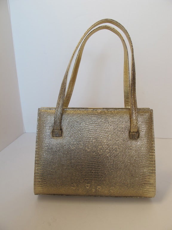 Stunning Lambertson Truex gold ring lizard handbag with rich gold lining and closure with logo. It is perfect for day or evening. Width at top 7.25 inches, Width at bottom: 8 inches, Depth 1.5 inches, Handles 15.5 inches, Height 6 inches.