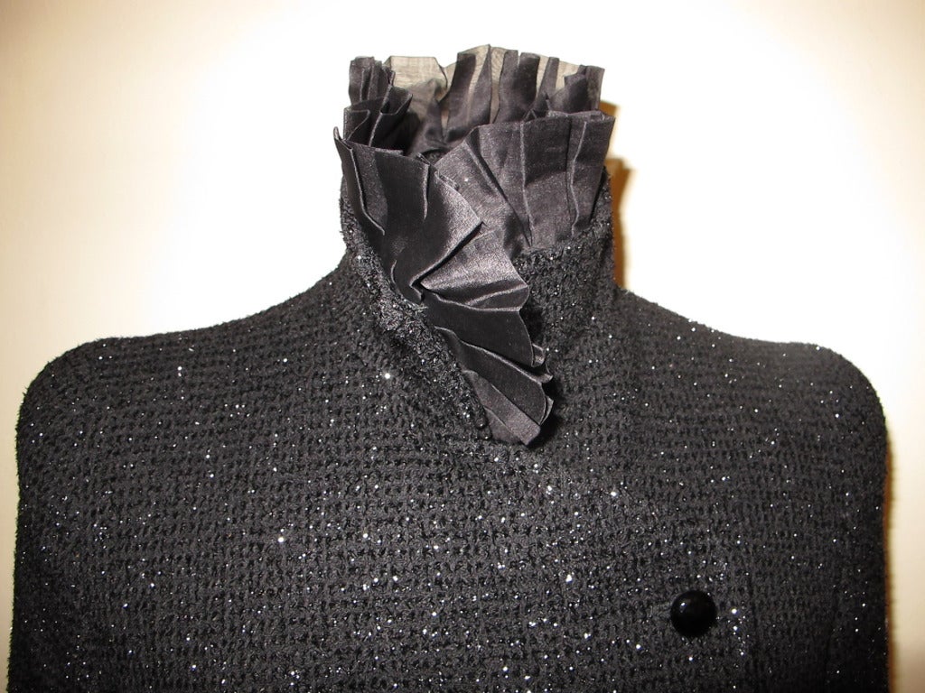 Exquisite jacket enhanced by glittery shiny threads running through beautiful fabric. Four black faceted glass buttons close the jacket. 2.75 inch choker collar is fastened with 2 inch pleated choker collar. This piece is stunning. Sleeves are