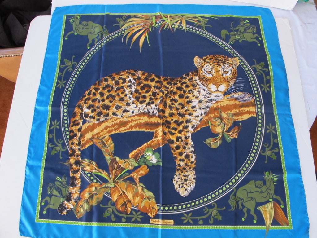Fabulous Leopard resting on a branch with Trojan theme of men and horses in four corners. Turquoise border with rich colors of navy, green, black, vicuna and warm golden beige.