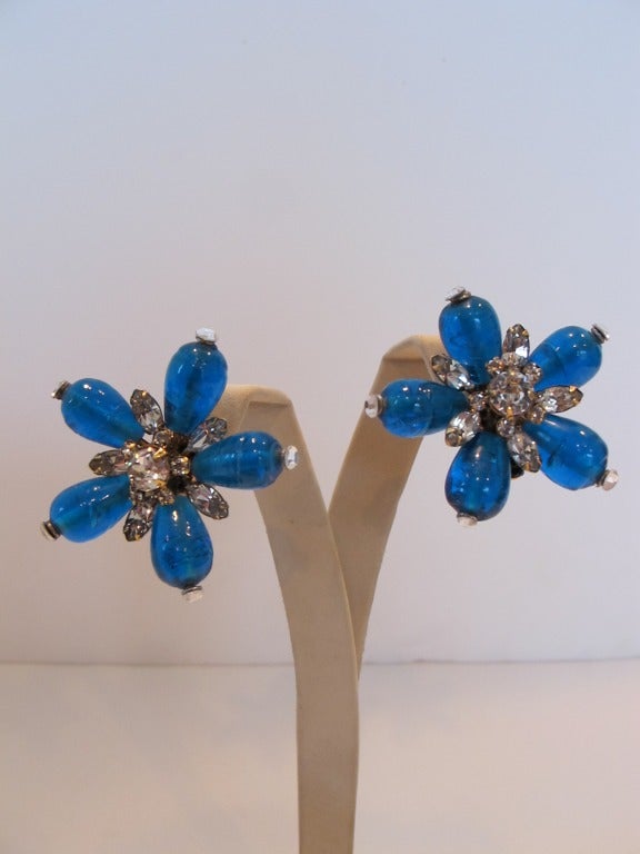 Iradj Moini luscious, brilliant ocean blue stones forming a flower, accentuated by rhinestones. The five petals form each earring. Clip on backs.