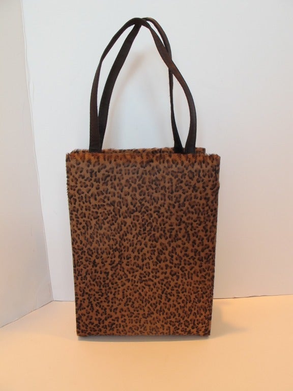 Charming chic mini leopard print Bottega Veneta handbag with name embroidered on one side of the bottom of the handbag. Side panels and handles are brown, heavy satin. Handle all around: 15 inches - .5 inch width.
