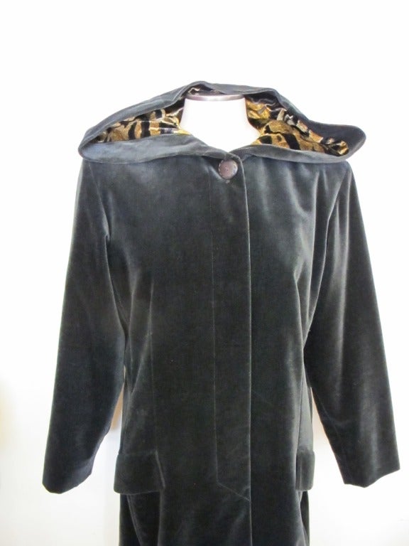 Yves St. Laurent Rive Gauche gorgeous grey velvet coat with one large button on neck and 5 hidden buttons. The luxurious hood is lined in silk tiger velvet fabric. The coat reeks of style. It has two hidden pockets. Sleeve length measures 24 inches.