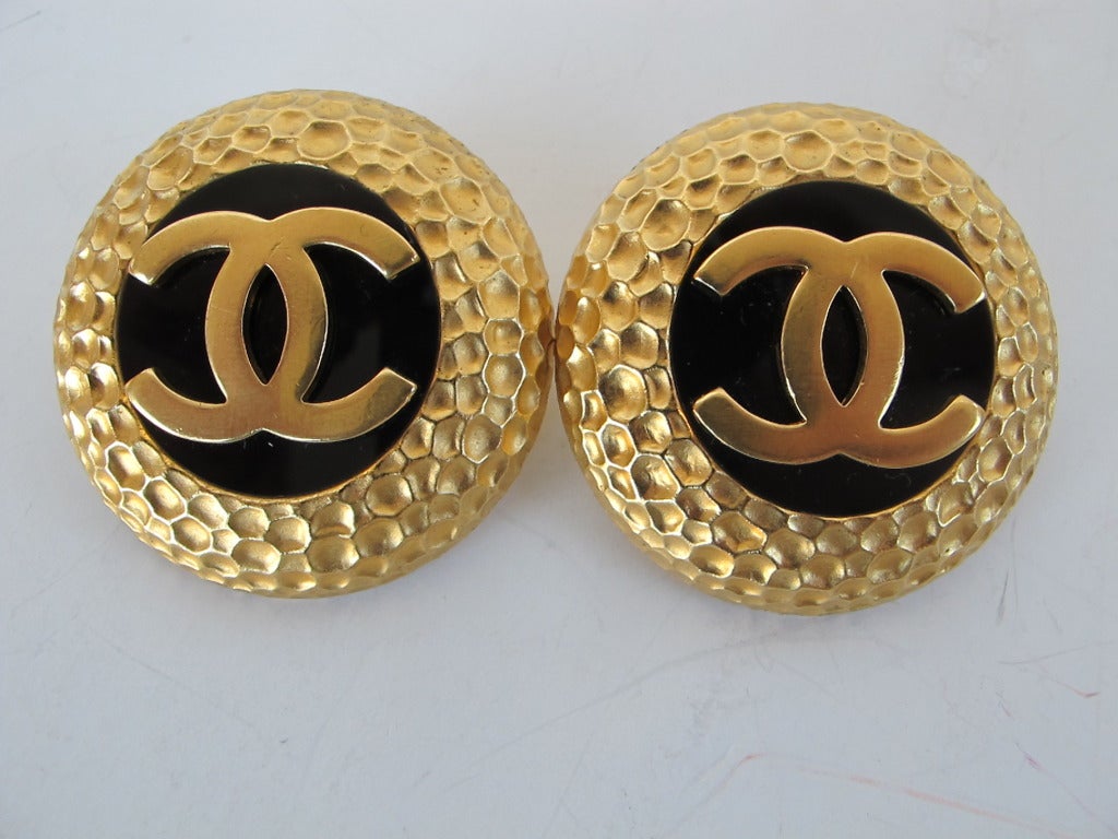 Large fabulous Chanel hammered faux gold and black earrings with Chanel logo.
