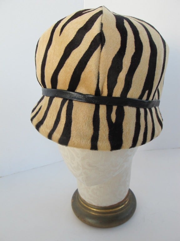 This chic 1970's hat was created for Lord + Taylor's Hat Salon. It is worn on top of the head - jockey style or stewardess style. Black stripes on light camel. Measures 22.5 inches around rim.