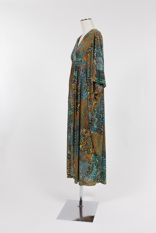 Gorgeous vintage caftan by Carolyn of Montreal with turquoise, green, yellow, orange and white abstract geometric designs on a dark brown background. Total length of front measures 52 inches while back measures 57 inches. Inner elastic waistband