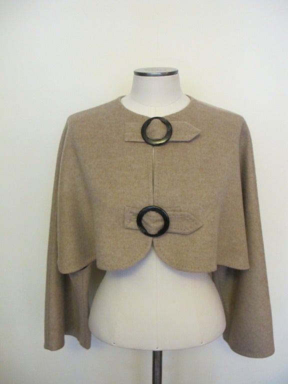 Elegant Akris Oatmeal jacket. It is chic, gorgeous and over-the-top. Hand-stitching surrounds the jacket. Circular buckles are made from horn and serve as closure to the jacket.