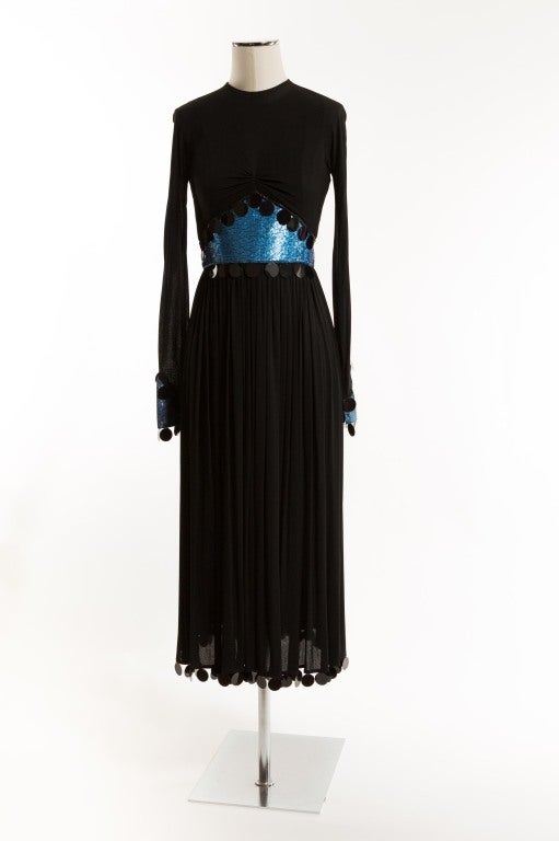 Dazzle the room with this black fine jersey dress adorned with sky blue toned sequins, shimmering blue panne velvet cuffs and 1
