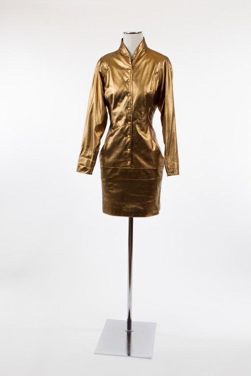 Absolutely fabulous antique golden bronze leather dress by Ungaro Parallele Paris. Raglan sleeves with fitted cuffs with zippers, sleeves measure 24 inches. Eight gold buttons and fabulous black silk lining. Labeled size 10, will fit modern size