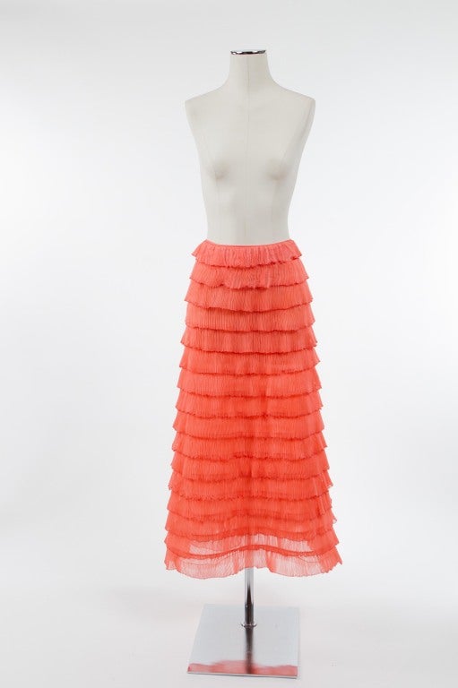 Flirty and fun! Sixteen tiers of melon sherbert pleated ruffles in an A line silhouette; each layer is hemmed in an equally delicious matching melon trim; the whole skirt is lined in a sheer matching silk slip; back zipper. 

Photography provided