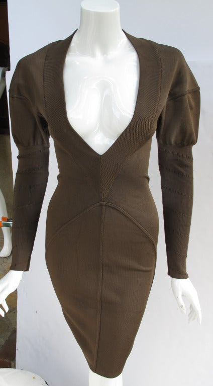 An early 1990's Alaia dress in a mocha color with sage undertones. Featuring a deep v-neck, mutton sleeves and body contouring shape. Fabric is a mix of rayon, polyester and spandex. Size tag Small. Please consult measurements and allow 2-3 inches