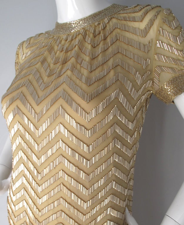 Late 1960s Donald Brooks creme-colored silk chiffon cocktail dress embroidered with bugle beads in a chevron pattern. Underneath there is a nude-colored silk slip with spaghetti straps that attaches at the shoulders. It is in very good condition