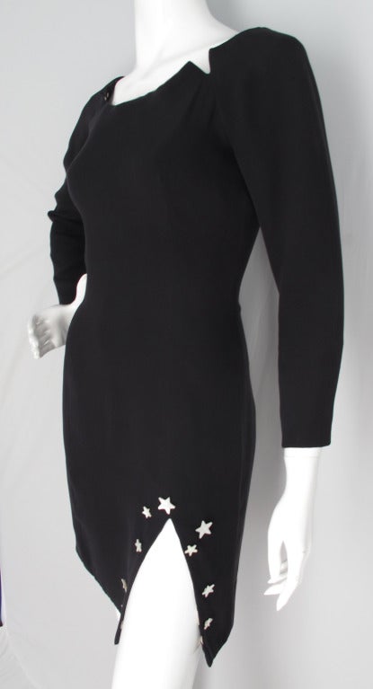 Schwarzes Seidenkleid von Geoffrey Beene aus dem Jahr 1988 mit einem kniehohen Schlitz, der mit Perlmuttsternen verziert ist. Es besteht aus zwei Lagen Seide und ist an Hals, Ärmeln und Saum mit Seiden-Charmeuse in einem Muster aus Sonne, Mond und