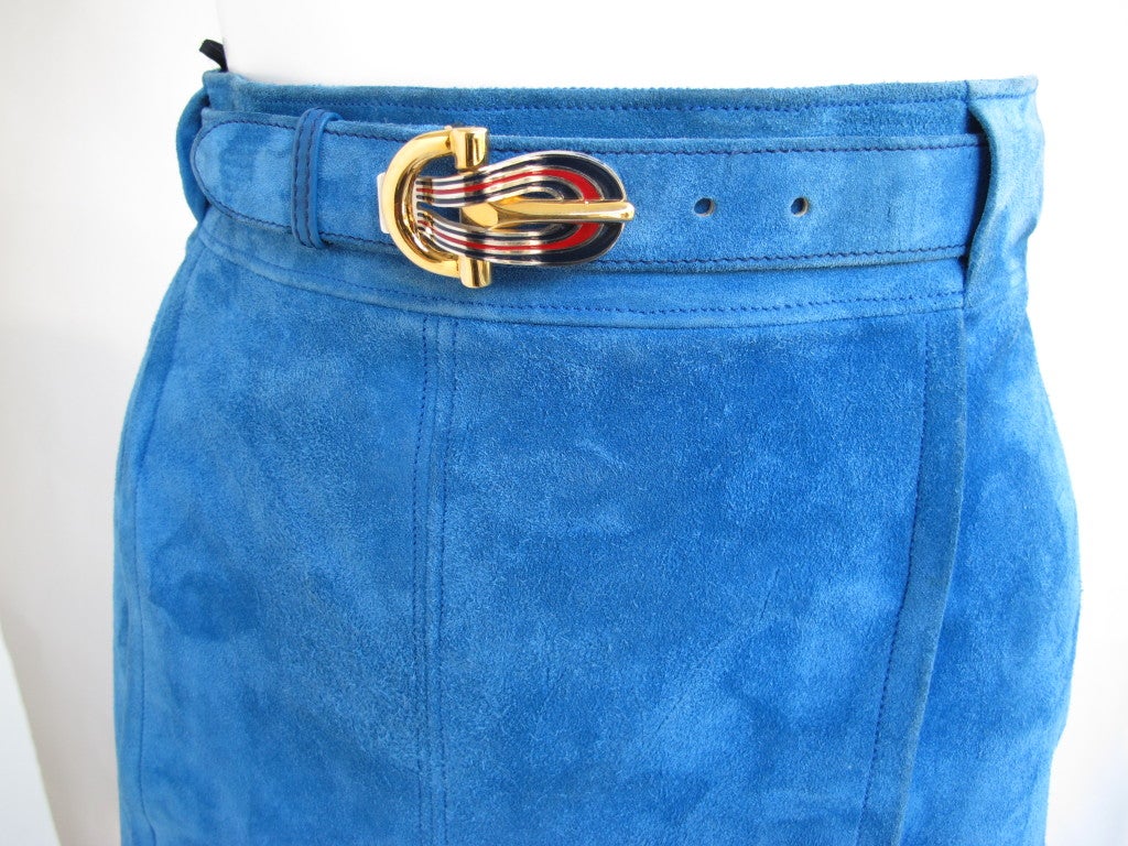Authentic vintage Gucci electric blue suede leather skirt accented by a stamped Gucci enamel and gold metal horsebit/horseshoe belt. The skirt features a kick pleat down the center and is entirely lined with Gucci logo 100% silk fabric. Size tag is