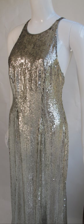 A silver sequin Ralph Lauren Collection Purple Label floor-length gown from either '96 or '97. The dress is lined with gray silk and criss-crosses at the back. Tag Size 8 - the hips have been taken in and made narrower.
MEASUREMENTS: 
Length: