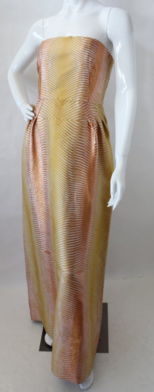 Missoni strapless metallic jacquard gown in a palette of creme, yellow and metallic-copper. Featuring a geometric design, the gown has a straight neckline, built-in boned strapless bra top with concealed hook fastenings, fitted waist with pleats