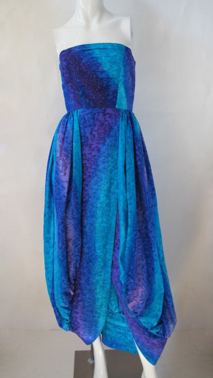 Bill Blass watermark silk strapless gown in an impressionist swirl of blues, greens and purples. The fabric has been treated with what looks like a mixture of batik meets tie-dye. The skirt is comprised of two overlapping and bubbled panels which